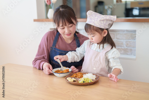 カレーを盛り付ける親子　女の子とお母さん
