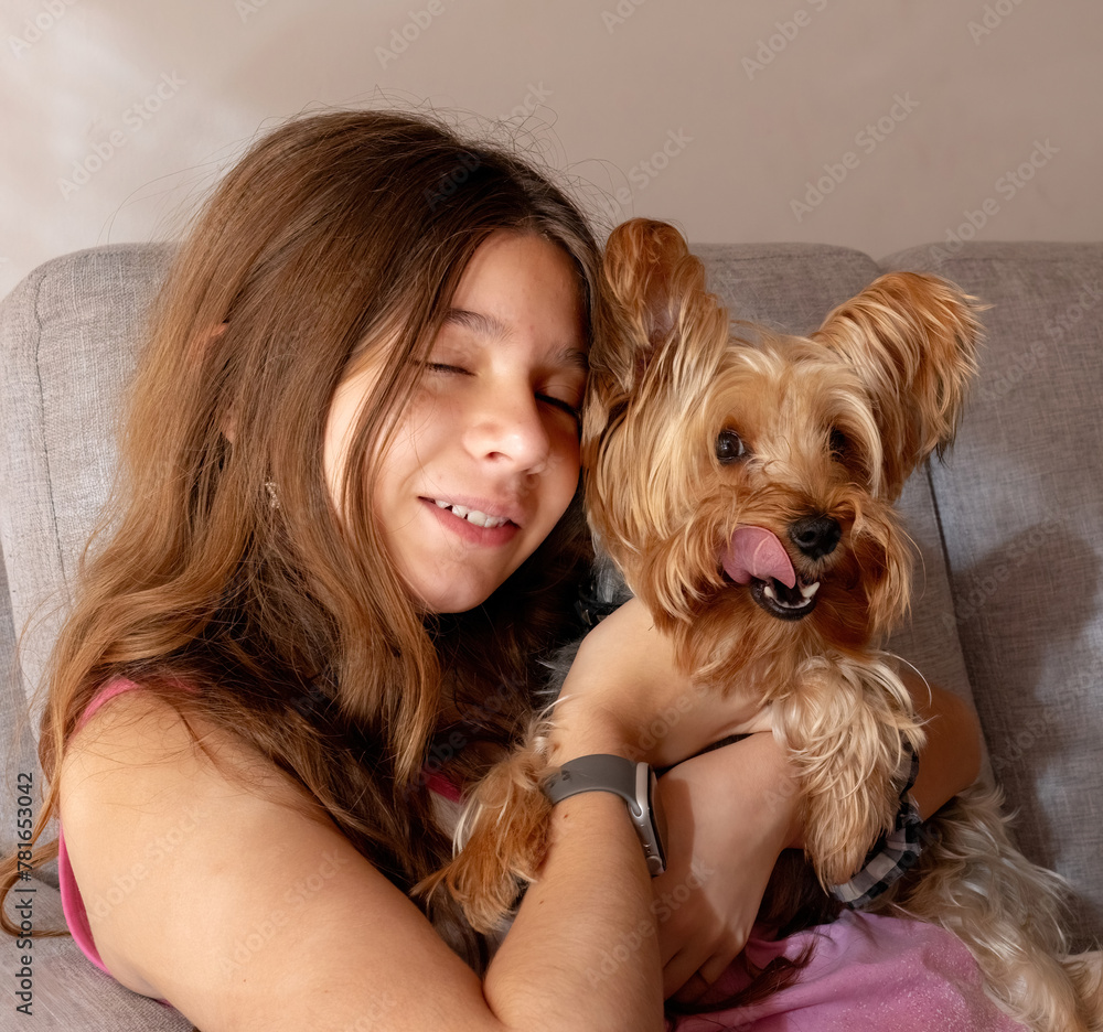 Beautiful caucasian girl playing with her cute Yorkie.The pet in a very funny expression Beautiful caucasian girl playing with her cute Yorkie.The pet in a very funny expression