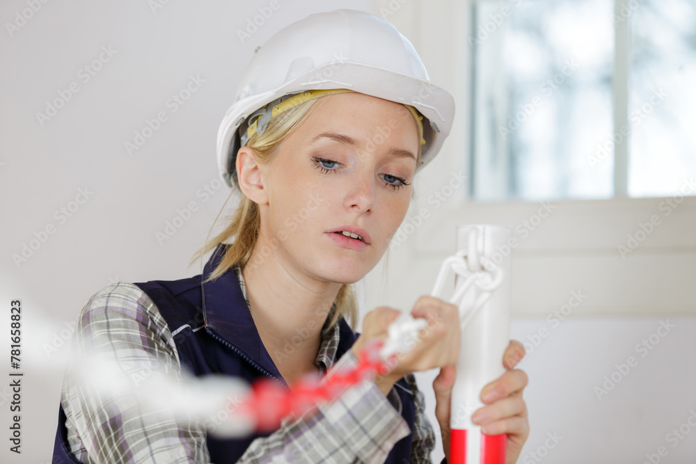 female builder indoors at the working area - obrazy, fototapety, plakaty 
