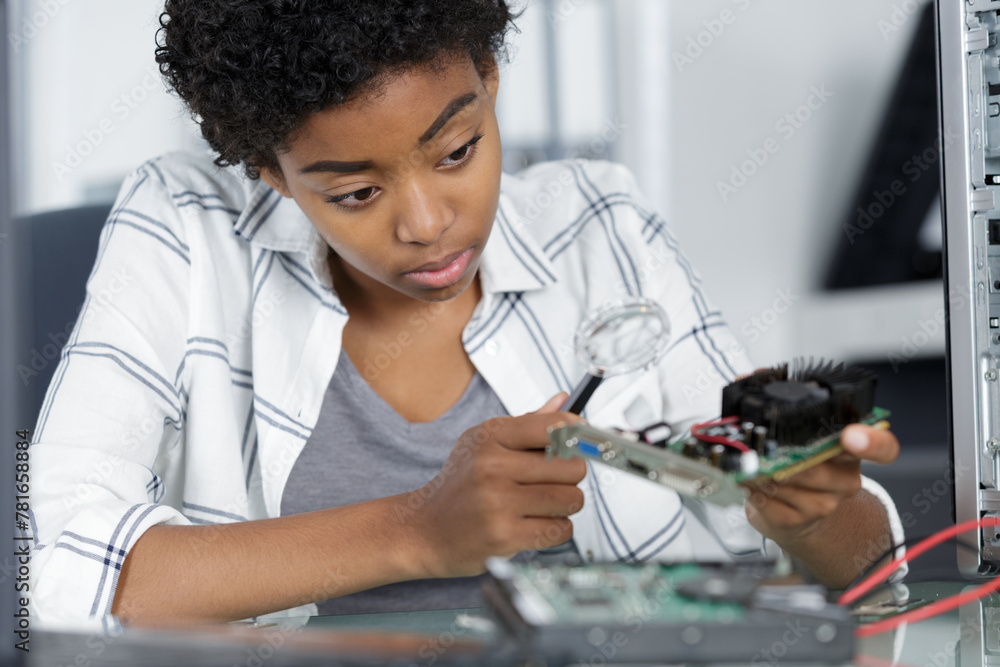 woman computer technician repairs a computer - obrazy, fototapety, plakaty 