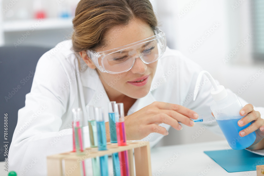 student doing chemistry test with liquids and tubes - obrazy, fototapety, plakaty 