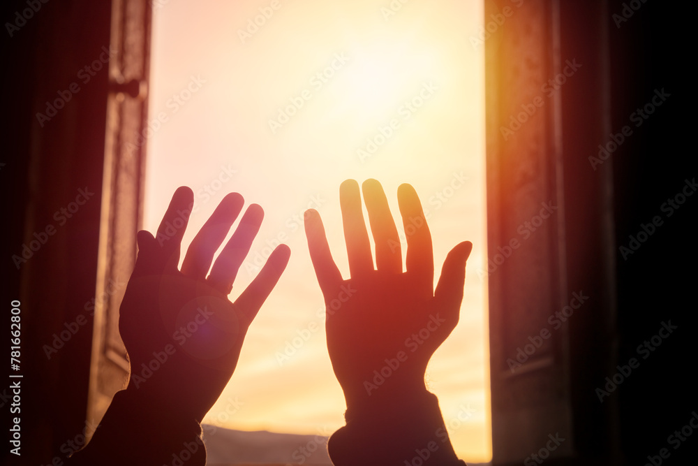 Hands raised in prayer towards the light, spiritual concept, stock photo