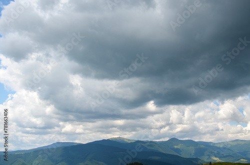 A serene and captivating landscape showcasing the majestic beauty of a mountain range with highest peak Pip Ivan with observatory enveloped in the soft embrace of cloudy skies. Carpathians, Ukraine 