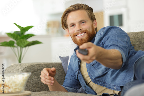 man smiling holding remote control