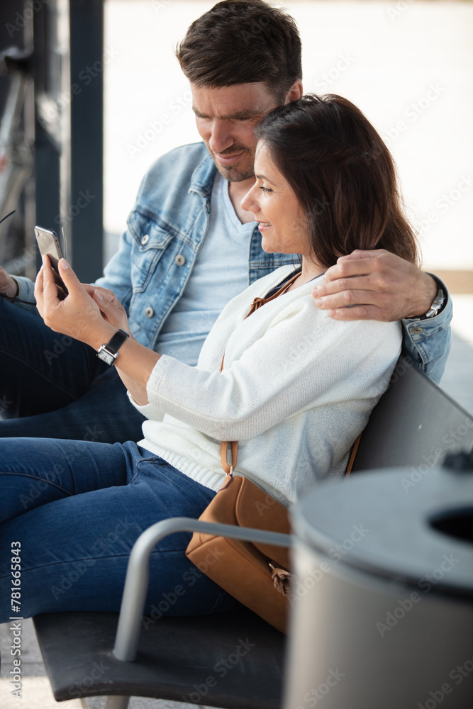happy couple enjoying media content in a smart phone - obrazy, fototapety, plakaty 