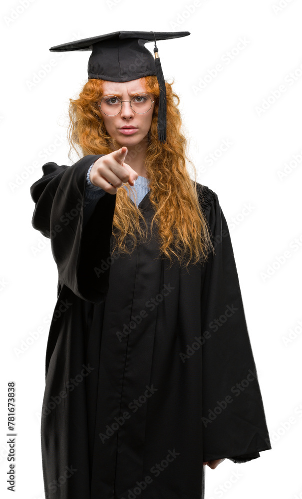 Young redhead student woman wearing graduated uniform pointing with finger to the camera and to you, hand sign, positive and confident gesture from the front Young redhead student woman wearing graduated uniform pointing with finger to the camera and to you, hand sign, positive and confident gesture from the front