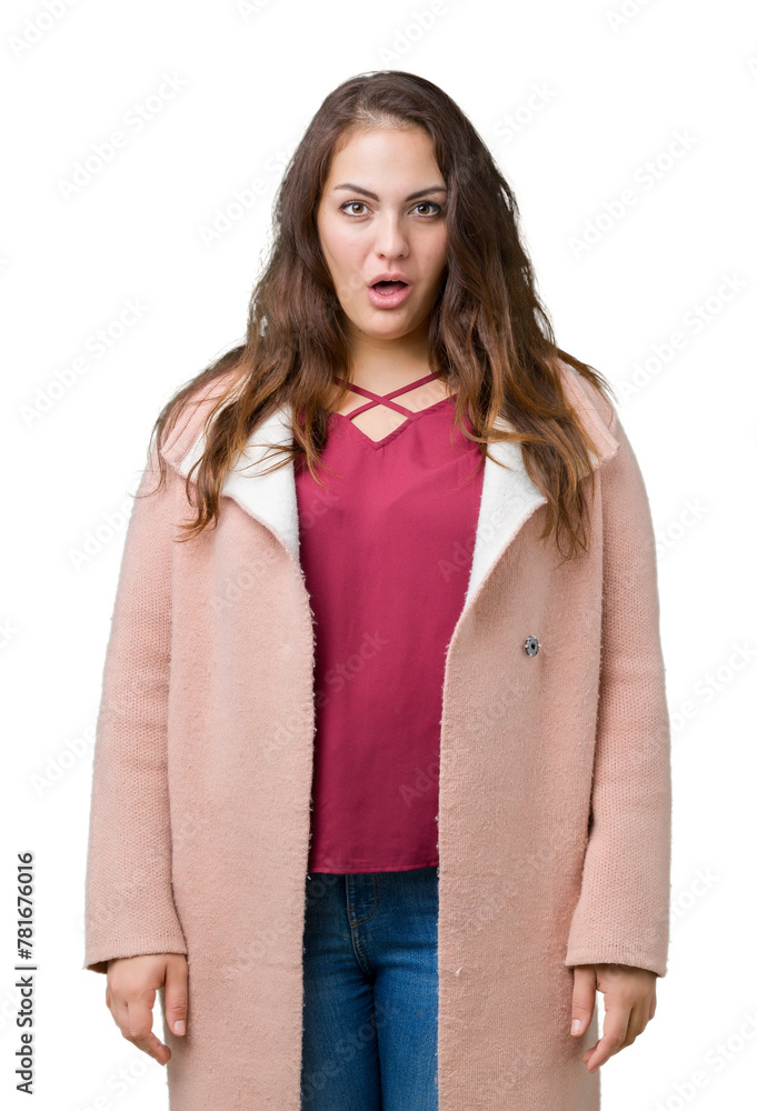 Beautiful plus size young woman wearing winter coat over isolated background afraid and shocked with surprise expression, fear and excited face.