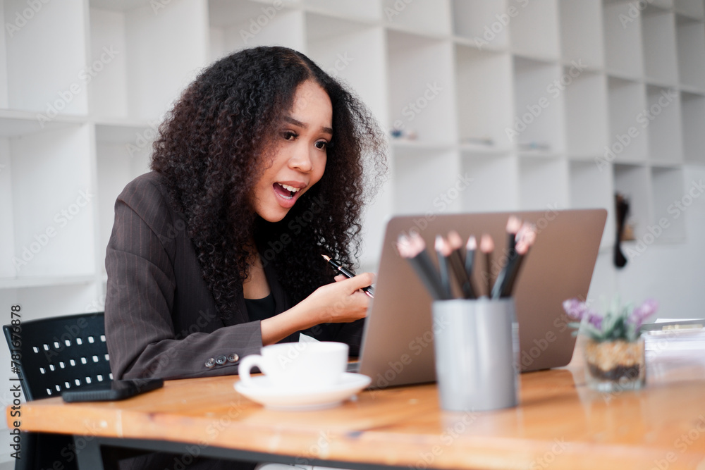 Surprised businesswoman reacts to unexpected results on her laptop screen, with a cup of coffee and office supplies on her desk. Surprised businesswoman reacts to unexpected results on her laptop screen, with a cup of coffee and office supplies on her desk.