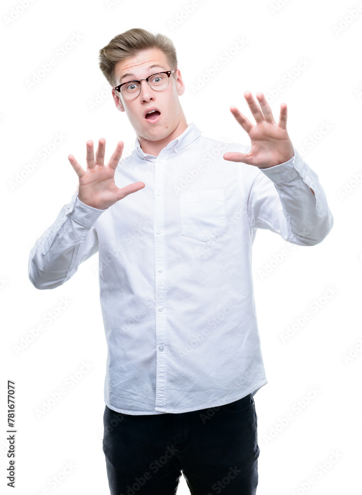 Young handsome blond man afraid and terrified with fear expression stop gesture with hands, shouting in shock. Panic concept. Young handsome blond man afraid and terrified with fear expression stop gesture with hands, shouting in shock. Panic concept.