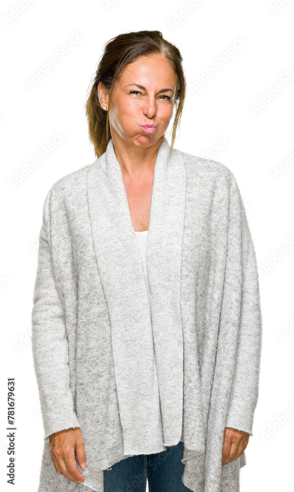 Beautiful middle age adult woman wearing winter sweater over isolated background puffing cheeks with funny face. Mouth inflated with air, crazy expression. Beautiful middle age adult woman wearing winter sweater over isolated background puffing cheeks with funny face. Mouth inflated with air, crazy expression.