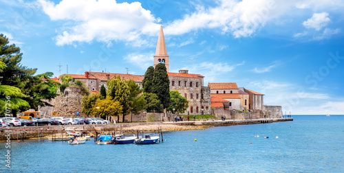 Amazing view of old Assumption of Mary church with sea and boats in foreground. Cityscape of Porec, Croatia, Europe. Traveling concept background photo
