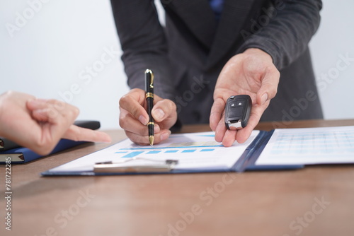 Agent Assurance Securing Deals with Confidence close up man working with car contract document or lease paper at desk in loan car office.