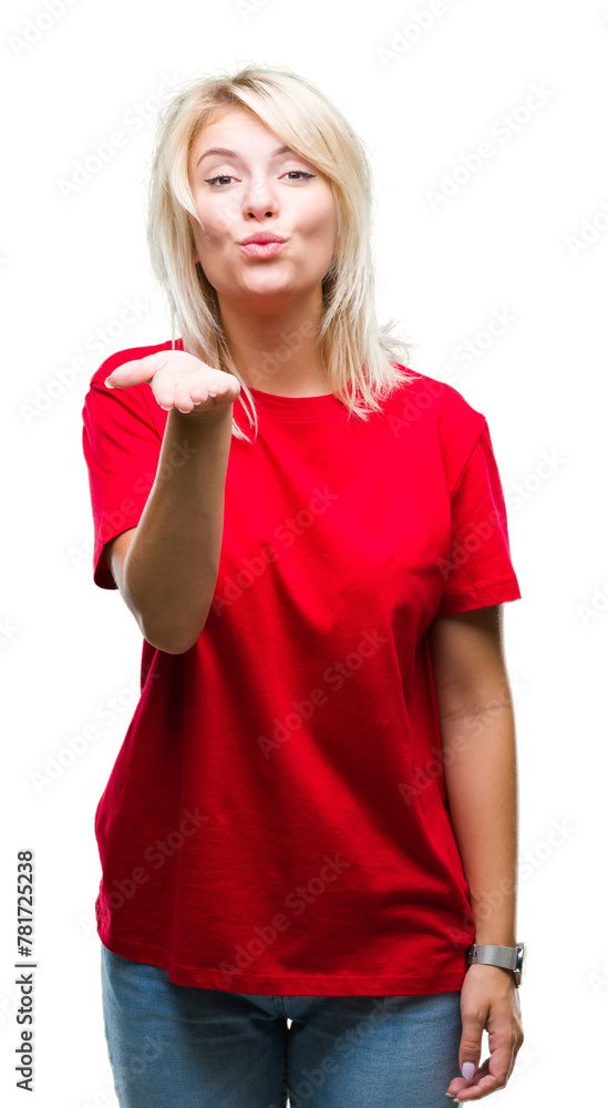 Young beautiful blonde woman wearing red t-shirt over isolated background looking at the camera blowing a kiss with hand on air being lovely and sexy. Love expression. Young beautiful blonde woman wearing red t-shirt over isolated background looking at the camera blowing a kiss with hand on air being lovely and sexy. Love expression.