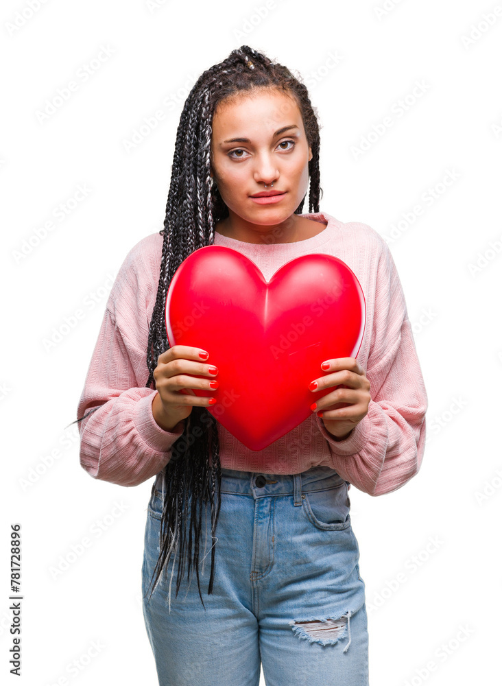 Young braided hair african american girl holding read heart over isolated background with a confident expression on smart face thinking serious Young braided hair african american girl holding read heart over isolated background with a confident expression on smart face thinking serious