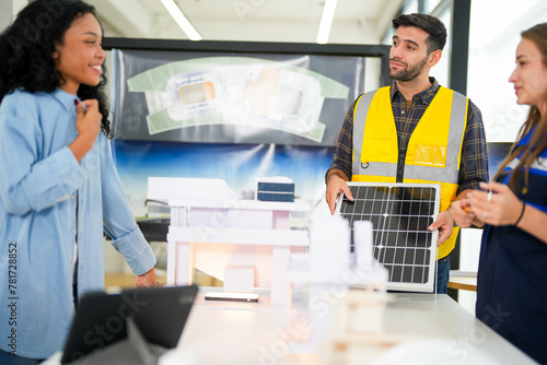 Focused construction specialists evaluate a solar energy panel model in a modern workspace with design drafts.