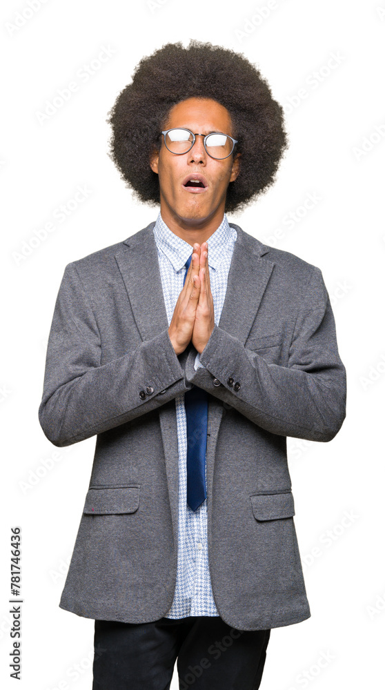 Young african american business man with afro hair wearing glasses begging and praying with hands together with hope expression on face very emotional and worried. Asking for forgiveness. Young african american business man with afro hair wearing glasses begging and praying with hands together with hope expression on face very emotional and worried. Asking for forgiveness.