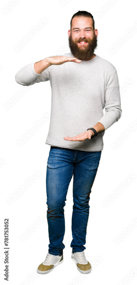 Young blond man wearing casual sweater gesturing with hands showing big and large size sign, measure symbol. Smiling looking at the camera. Measuring concept. Young blond man wearing casual sweater gesturing with hands showing big and large size sign, measure symbol. Smiling looking at the camera. Measuring concept.