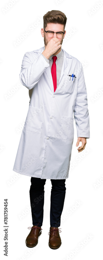 Young handsome scientist man wearing glasses smelling something stinky and disgusting, intolerable smell, holding breath with fingers on nose. Bad smells concept. Young handsome scientist man wearing glasses smelling something stinky and disgusting, intolerable smell, holding breath with fingers on nose. Bad smells concept.