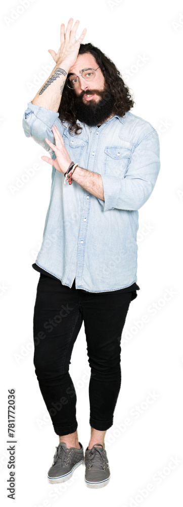 Fototapeta premium Young hipster man with long hair and beard wearing glasses surprised with hand on head for mistake, remember error. Forgot, bad memory concept.