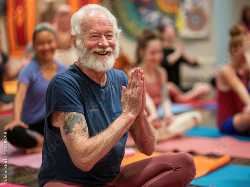 a happy senior man in a yoga class, doing deep breathing exercises with his hands together at chest level surrounded by other people