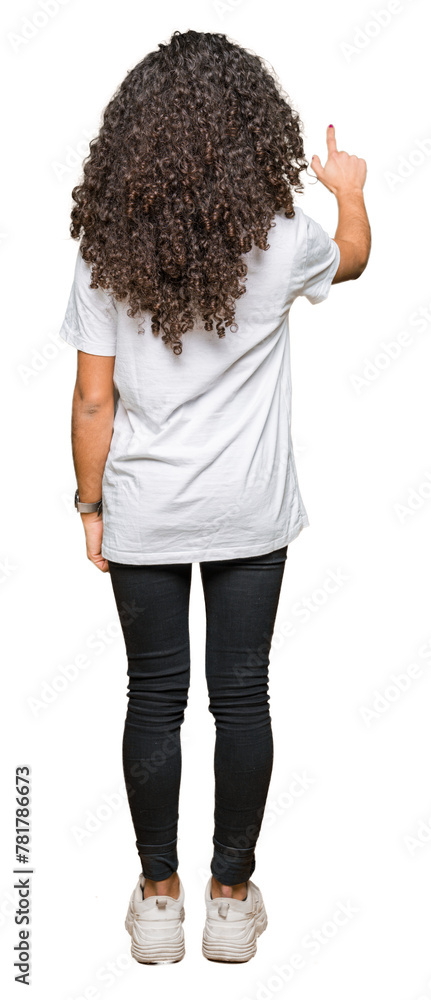 Young beautiful woman with curly hair wearing white t-shirt Posing backwards pointing behind with finger hand Young beautiful woman with curly hair wearing white t-shirt Posing backwards pointing behind with finger hand