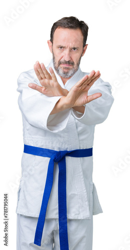 Handsome middle age senior man wearing kimono uniform over isolated background Rejection expression crossing arms and palms doing negative sign, angry face