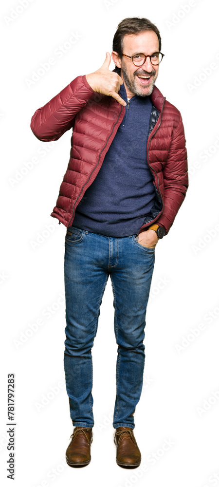 Middle age handsome man wearing glasses and winter coat smiling doing phone gesture with hand and fingers like talking on the telephone. Communicating concepts. Middle age handsome man wearing glasses and winter coat smiling doing phone gesture with hand and fingers like talking on the telephone. Communicating concepts.