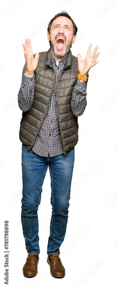 Middle age handsome man wearing winter vest crazy and mad shouting and yelling with aggressive expression and arms raised. Frustration concept. Middle age handsome man wearing winter vest crazy and mad shouting and yelling with aggressive expression and arms raised. Frustration concept.