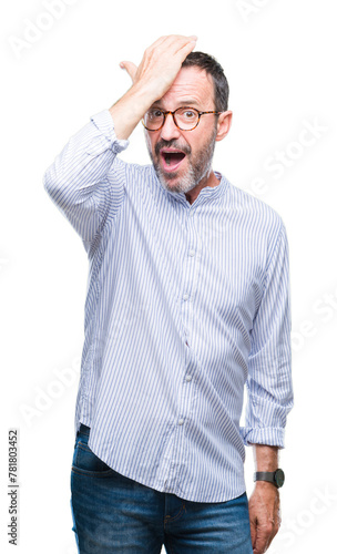 Middle age hoary senior man wearing glasses over isolated background surprised with hand on head for mistake, remember error. Forgot, bad memory concept.