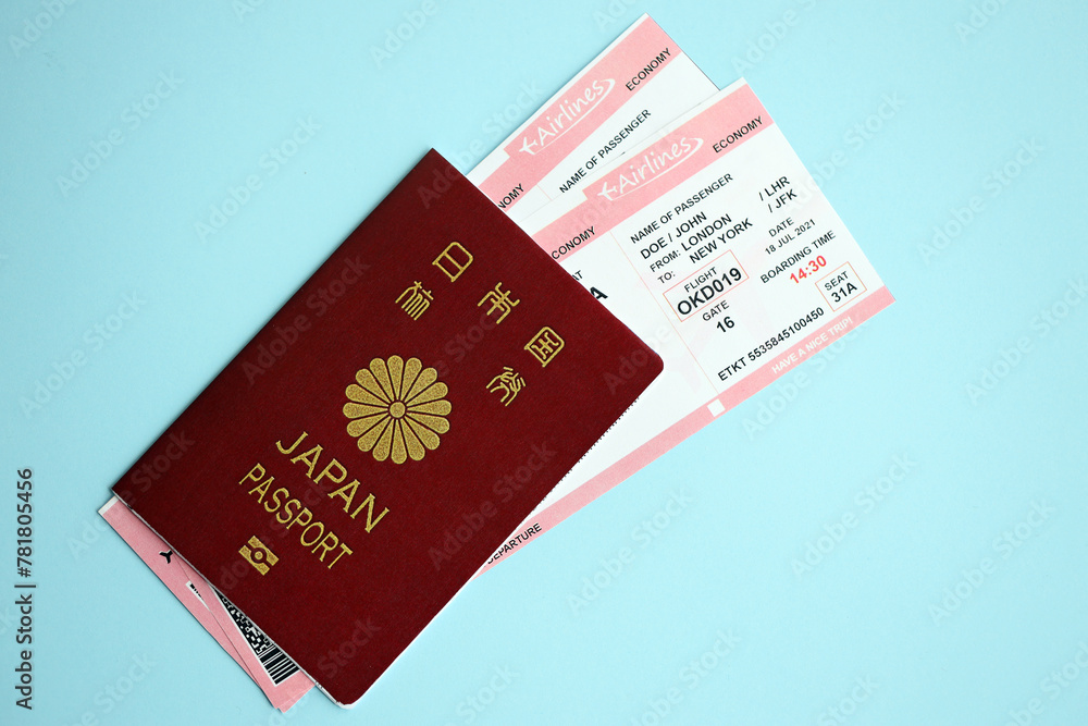 Japan passport with airline tickets on blue background close up. Tourism and travel concept Japan passport with airline tickets on blue background close up. Tourism and travel concept