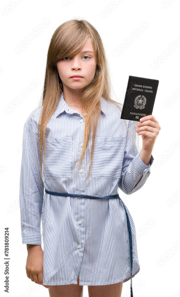 Young blonde toddler holding italian passport with a confident expression on smart face thinking serious Young blonde toddler holding italian passport with a confident expression on smart face thinking serious