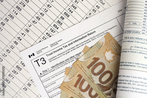 Canadian T3 tax form Trust income tax and information return lies on table with canadian money bills close up. Taxation and annual accountant paperwork in Canada