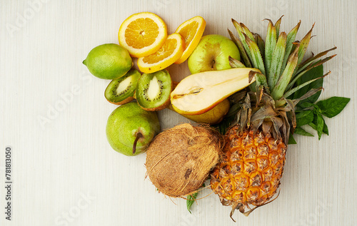 Group, tropical and fruit on table for health, smoothie and vegan diet by light background with coconut. Pear, kiwi and vitamin c with nutrition on wood surface for weight loss, milkshake and energy