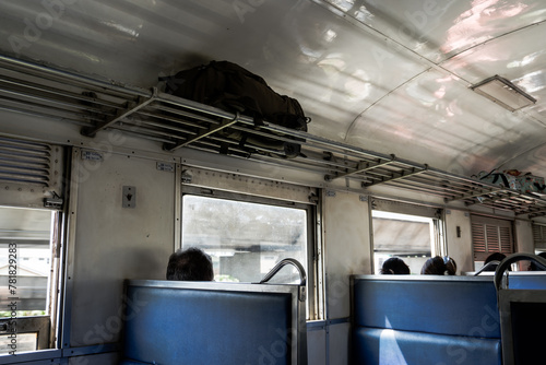 Empty passenger seats line the interior of a modern train car