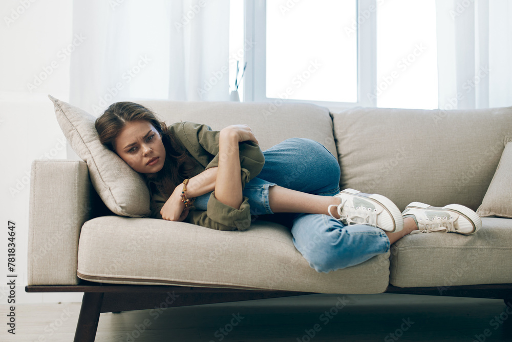 Lonely Woman Sitting on a Couch, Expressing Sadness and Worried Emotions, Capturing Mental Health Pain and Depression at Home Lonely Woman Sitting on a Couch, Expressing Sadness and Worried Emotions, Capturing Mental Health Pain and Depression at Home