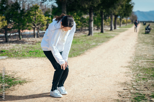 ランニング中に膝を痛める女性　jogging in park
