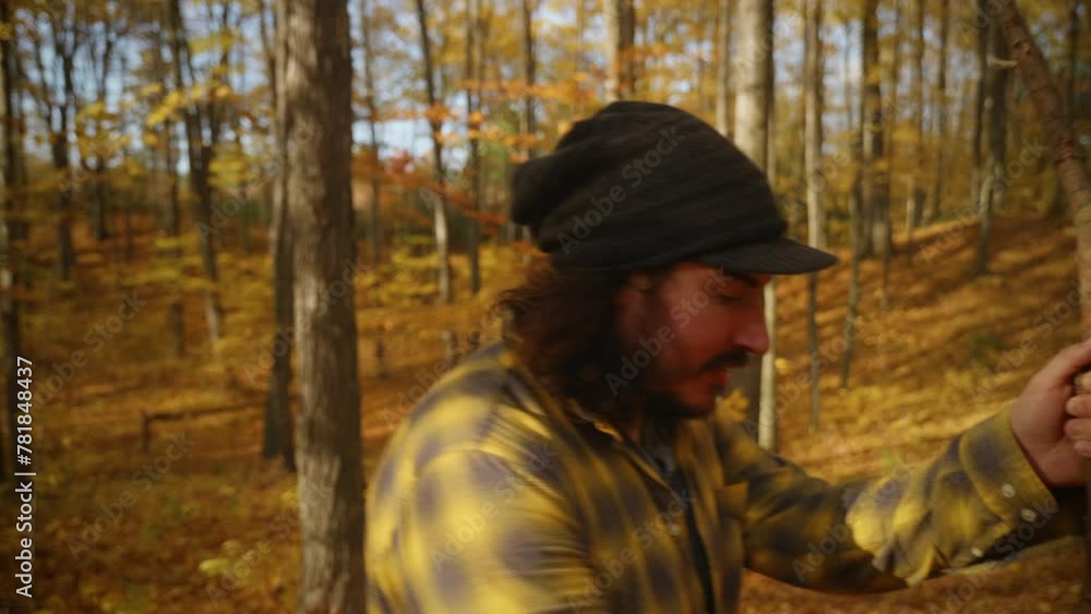 Man walks through forest during Autumn and looks up at trees. Man walks through forest during Autumn and looks up at trees.