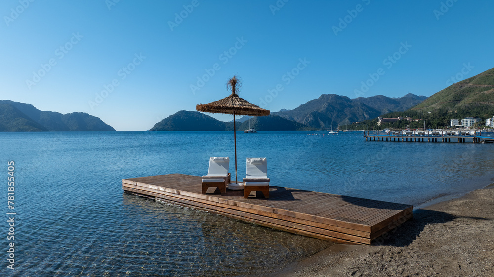 Empty deck sun bed with comfy mattresses on a wooden pier by the tranquil Mediterranean Sea. Perfect for evoking seaside relaxation and holiday vibes. Great for travel ads, vacation Empty deck sun bed with comfy mattresses on a wooden pier by the tranquil Mediterranean Sea. Perfect for evoking seaside relaxation and holiday vibes. Great for travel ads, vacation