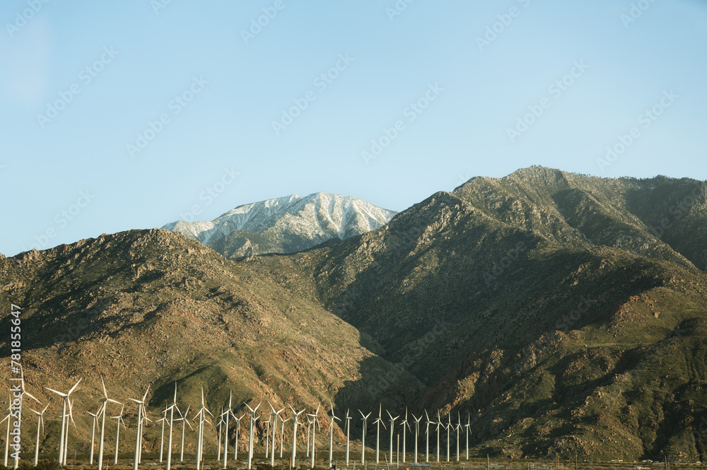Fototapeta premium Wind turbines located by mountains in California on a sunny day