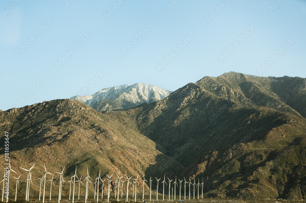 Wind turbines located by mountains in California on a sunny day