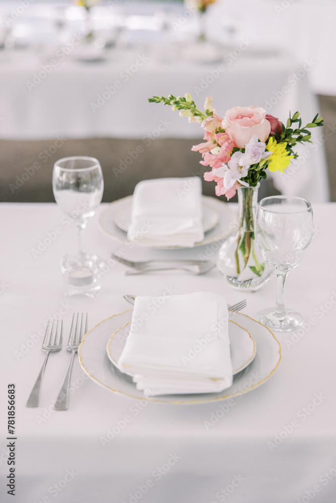 Elegant wedding table setting with pink floral accent