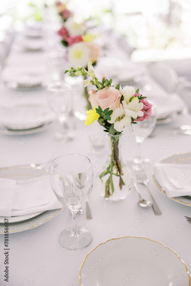 Elegant table setting with fresh flower centerpiece Elegant table setting with fresh flower centerpiece
