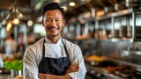 Smiling Asian Chef with Arms Crossed in Commercial Kitchen