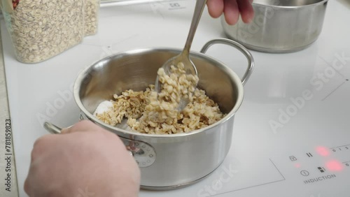 The video shows oatmeal cooking in a saucepan, demonstrating the process of preparing a healthy breakfast. Suitable for culinary clips and promoting a healthy lifestyle