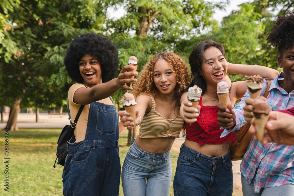Fototapeta premium Ecstatic Young Friends Offering Ice Cream Cones to the Camera