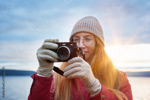 Pretty smiling female photographer with lake view