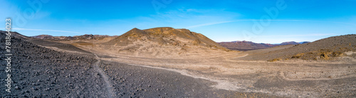 Panoramic view from Askja volcano in the lifeless volcanic desert in Highlands, with stones and rocks thrown by volcanic eruptions, Iceland, summer, blue sky.