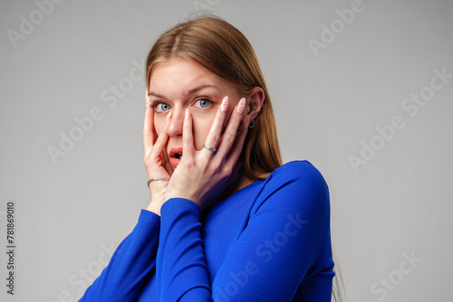 Young Woman Covering Face With Hands against gray background