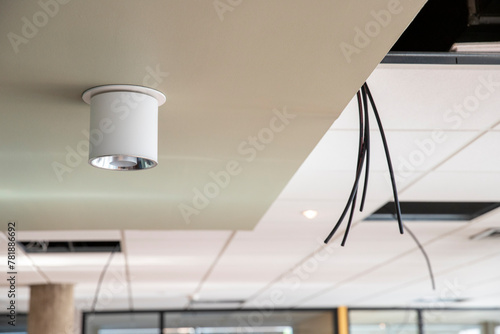 Installation au plafond de câble électrique pour alimenter des luminaires photo