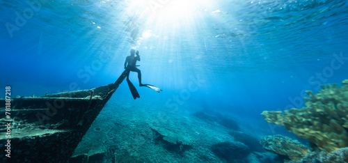 Freediver Sitting on Shipwreck in Shallow Sea With Sea Grass. © Jag_cz